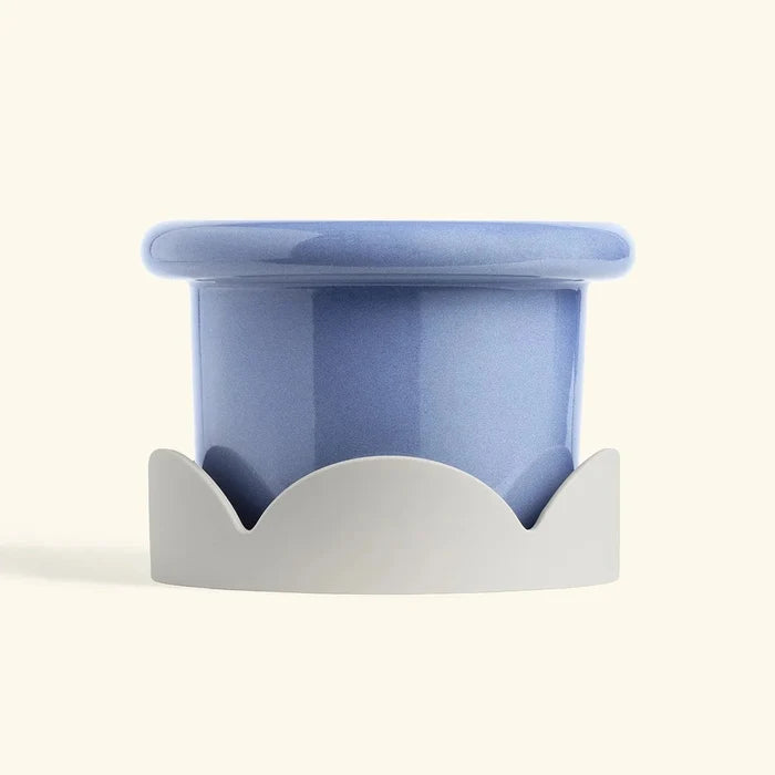 Blue ceramic drip tray with beige petal-shaped base designed for home decor or planter protection